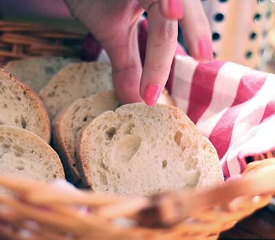 Person taking bread from a basket